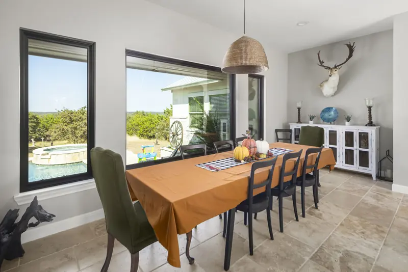 Black-framed picture window over the pool and spa in a dining room